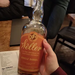 a person holding a bottle of wellen single barrel