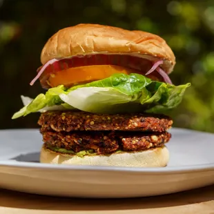 Vegan Burger - bean &amp; seed patty, guacamole, heirloom tomato, lettuce, pickled onion, roast-garlic tahini, vegan bun