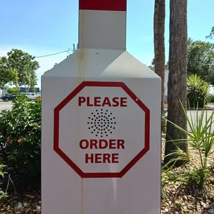 a red and white sign that says please order here