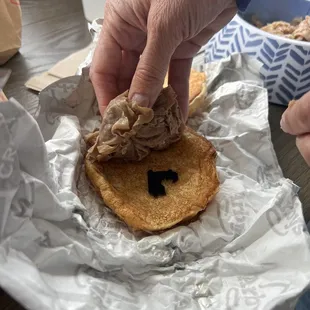 a person grabbing a piece of food from a wrapper