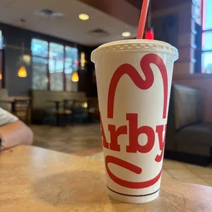 a drink in a paper cup with a straw