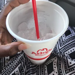 a person holding a cup of ice