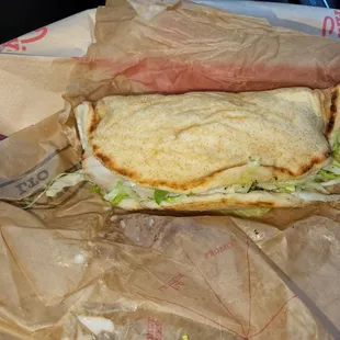 a sandwich wrapped in brown paper