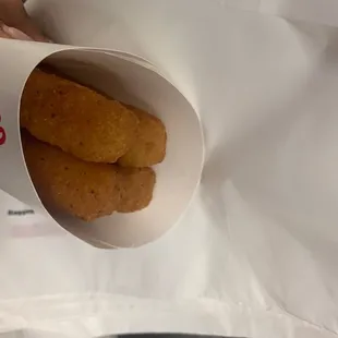 a person holding a bag of chicken nuggies