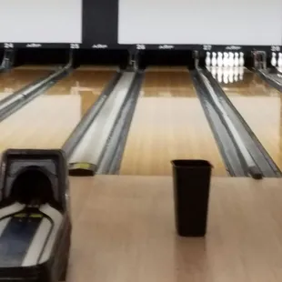 Trash can catching water from leaking roof and broken lanes.