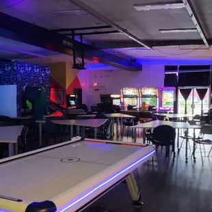 View from the back of the room - lots of tables/chairs, games, big screen tv playing Kung Fu Panda