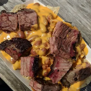 Serious pile of brisket nachos with beans and cheese!