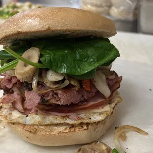 Egg Sandwich with Pastrami, Ham, Mushroom, Onion and Spinach on a bagel