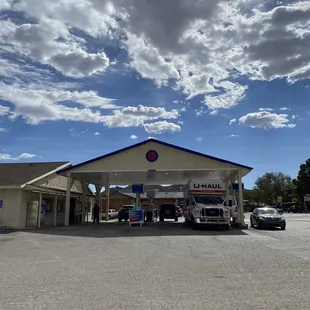 a gas station with cars parked in front of it