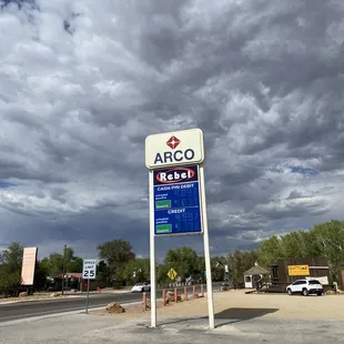a gas station with a cloudy sky in the background