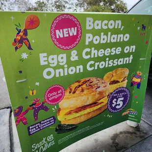 a sign advertising a new bacon, egg and cheese on onion croissant