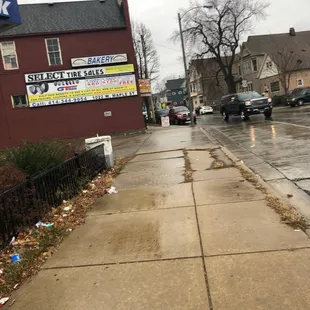 a wet sidewalk in front of a restaurant