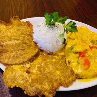 Coconut-Lime Chicken: Tender chicken in a Colombian coconut-lime sauce with red and green peppers. Served with white rice and tostones.