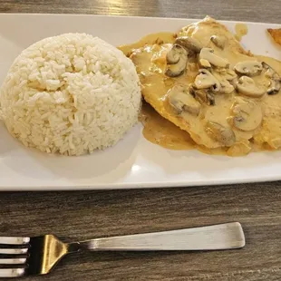 Chicken with mushrooms, served with sides, rice &amp; fried plantains in this case.