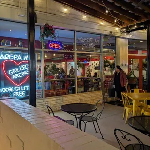 the outside of a restaurant with tables and chairs