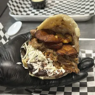 Arepa pabellón: Corn flour patty stuffed with house made black beans, fresco cheese, sweet plantains and premium hand pulled flank steak.
