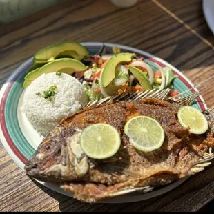a plate of fish with rice and avocado