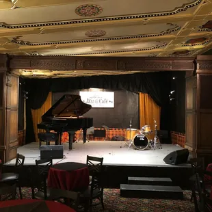 a stage with a piano and drums