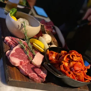 Meats to be cooked- shrimp, beef steak, spicy pork belly with raw mushrooms, onions and zucchini and yellow squash