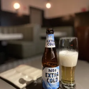 a bottle of extra cold beer next to a glass of beer