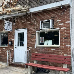 a red bench in front of a restaurant