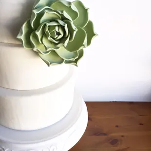 a three tiered cake with a flower on top