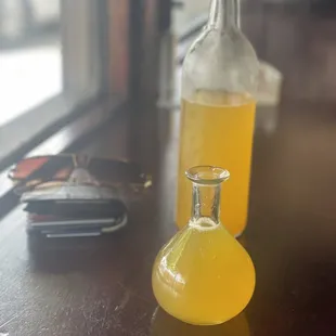 a bottle of orange juice and glasses on a table