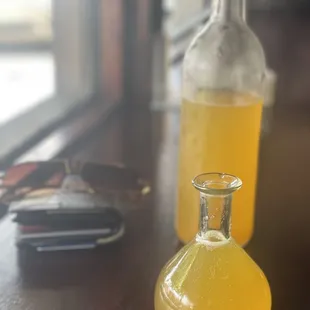 a bottle of orange juice and a wallet on a table