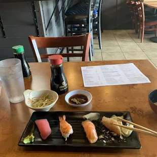 a woman sitting at a table with sushi