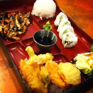 Teriyaki chicken, a cabbage salad, a house salad with ginger dressing, tempura, a California roll, and miso soup.