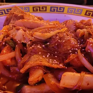 a bowl of stir fried beef and onions