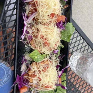 a plate of salad with cheese and lettuce