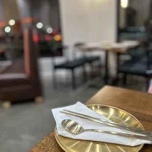 a gold plate with a fork and knife on it