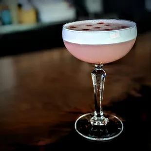 a pink cocktail in a coupe glass