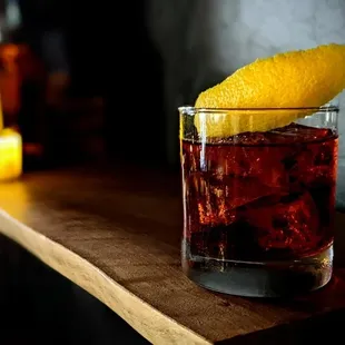 a drink in a glass with a lemon wedge