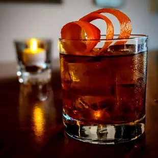 a drink with an orange garnish