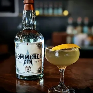 a bottle of commerce gin and a cocktail glass