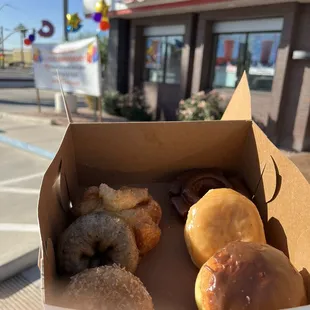 a box of doughnuts in front of a donut shop