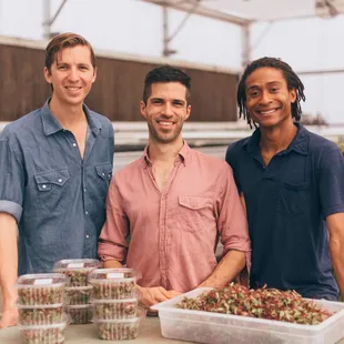 three men in a greenhouse