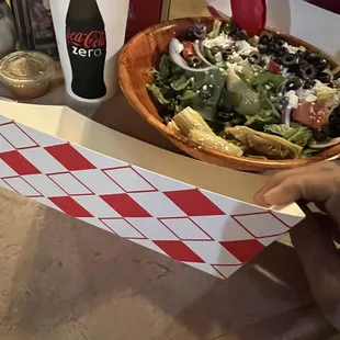 Half Greek salad and paper tray plate.