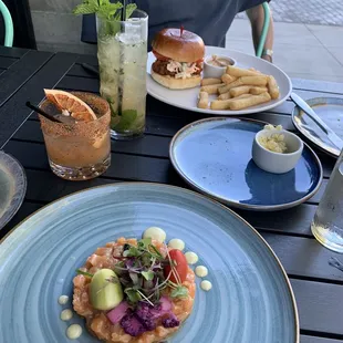 Salmon tartare, soft-shell crab sandwich, pink coral cocktail, and white peach mojito.