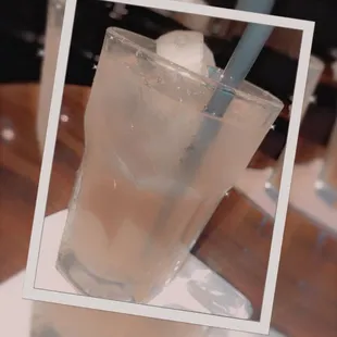a glass of water with ice and a straw
