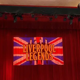 a stage with a red curtain and a banner that reads liverpool legends