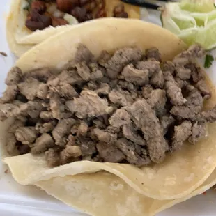 a plate of tacos with meat and lettuce