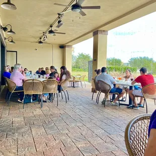 a group of people sitting at tables outside