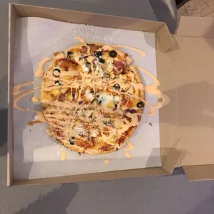 Fully loaded pizza topped with buffalo ranch sauce