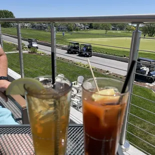 two drinks on a balcony overlooking a golf course