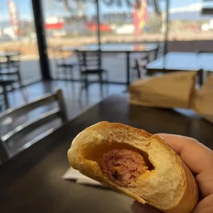 a hand holding a half eaten sandwich