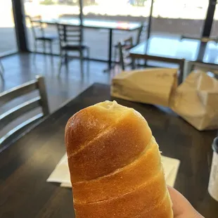a hand holding a donut