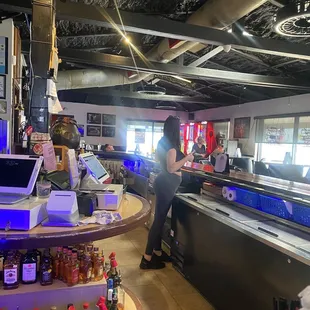 a man standing at the counter of a restaurant